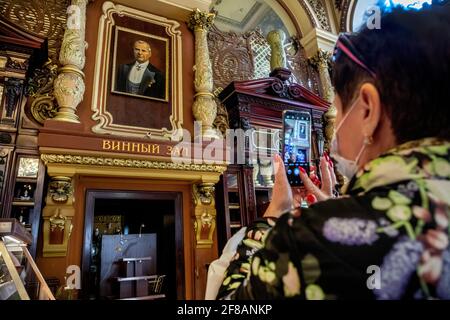 Moscow, Russia. 11th of April, 2021. Customers take pictures of an interior at the Yeliseyevsky store on the day of its closing. Considered Moscow's oldest grocery store, it was founded by merchant Grigory Yeliseyev back in 1901 as Eliseev's Shop and Cellars of Russian and Foreign Wines. On February 5 this year, the store marked 120 years since its opening Stock Photo