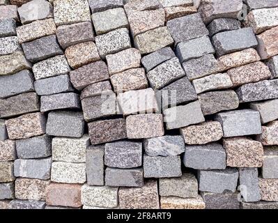 stacked grey granite stone tile for pavement construction. natural building material. Stock Photo