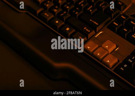 Gaming computer keyboard on a dark background. Up and down buttons on a computer keyboard. Stock Photo