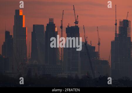 London, UK. 13 April 2021. Dawn breaks over central London skyscrapers with sunlight reflecting off the upper storeys of 22 Bishopsgate, the 62 storey, 912ft tall, office building in the City of London. Credit: Malcolm Park/Alamy Live News. Stock Photo