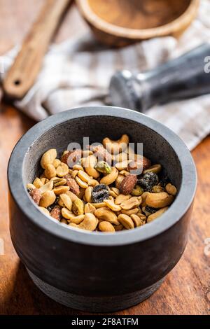 Mix of salted nuts in bowl on wooden table. Stock Photo