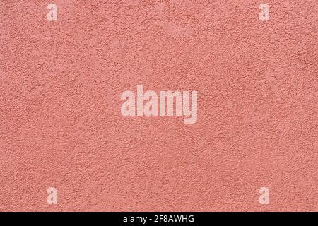The texture of the plaster on the exterior walls of the houses is painted in ocher color Stock Photo