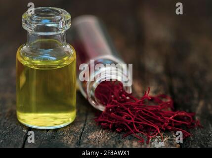 Closeup of Saffron with extract in a bottle on natural surface Stock Photo