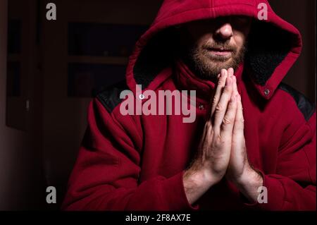 Suspicious bearded man in a hood in the dark Stock Photo