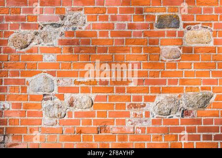 Beautiful background of old vintage red or orange brick wall with stones Stock Photo