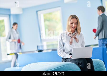 Adult businesswoman using computer in playroom relax zone Stock Photo