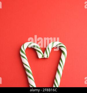 Christmas striped green and white heart shaped hard candies on red backgraund. Stock Photo
