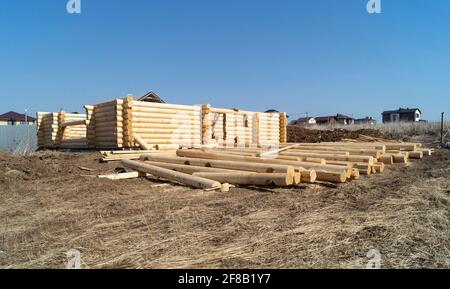 Construction of a wooden house on a sunny day in spring. New log house against the blue sky Stock Photo