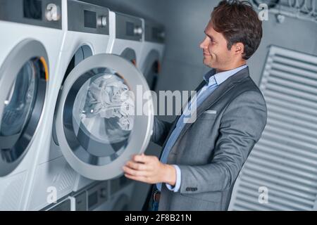 Young businessman in laundry room Stock Photo