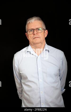 Senior Man Wearing Spectacles Against Black Stock Photo