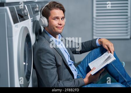 Young businessman in laundry room Stock Photo