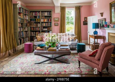 George Smith sofa  and gold curtains with chair upholstered in fabric by Allegra Hicks in living room of Suffolk farmhouse, walls in Squid Ink by Pain Stock Photo