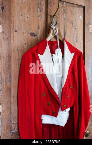 Antique red menswear hangs in Grade II listed Suffolk farmhouse Stock Photo