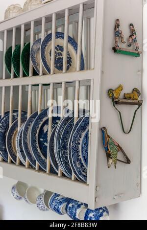 Vintage plates in rack with tongs in West Sussex kitchen. Stock Photo
