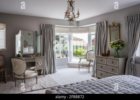 Gustavian dressing table with antique French chair and walls in Lamp Room Grey, West Sussex coastal bedroom. Stock Photo