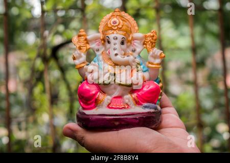 A beautiful idol of Lord Ganesha with a fresh green background Stock Photo