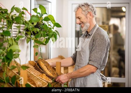 Man laying out fresh baking on rack Stock Photo