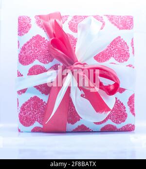Single gift box. Print Gift box in the shape of a heart with a ribbon on a white background. Stock Photo
