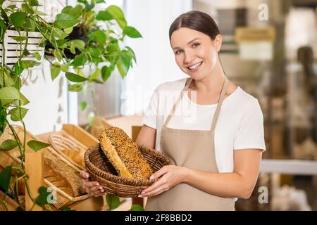 Woman in apron with basket of bread Stock Photo