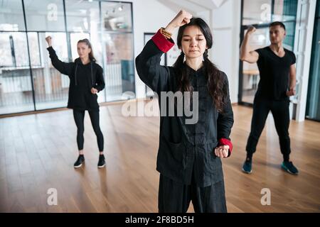 Classroom exercise of tai chi martial art for three athletes Stock Photo