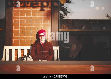 Adult woman in red sunglasses with closed eyes enjoying the sun Stock Photo