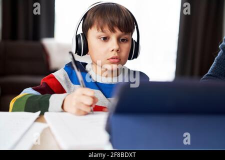 Boy in headphone during homeschooling Stock Photo
