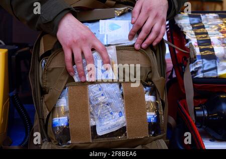 Backpack with soldier s first aid kit: bandages, wound-healing drugs, balloon with burn-treating gel, painkillers. Stock Photo