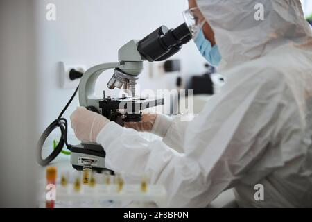 Lab technician examining an antiviral drug through the microscope Stock Photo