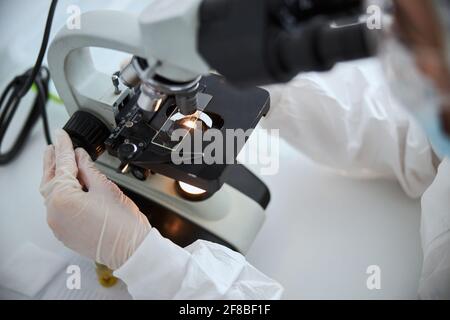 Microbiologist observing a microscopic specimen under the microscope Stock Photo