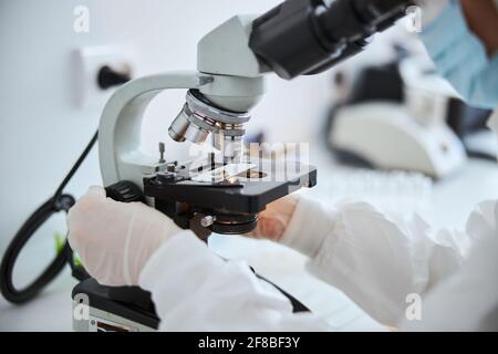 Lab technician examining cells under the microscope Stock Photo