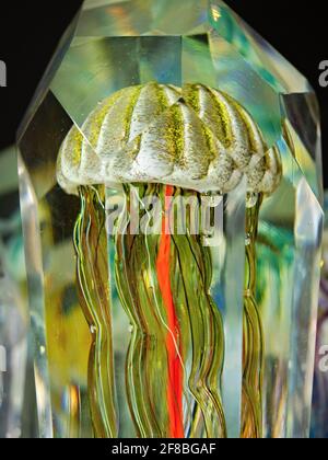 Cursed jellyfish in crystal glass. Glass paperweight and glassy ornament on the mantelpiece or director's office desk. Exhibition of handmade glass Stock Photo