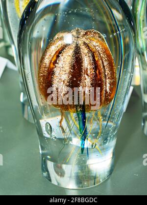 Fairytale sea world in crystal glass. Jellyfish in a glass paperweight on a director's office desk. Exhibition of handmade glass Stock Photo