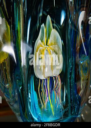 Fairytale sea world in crystal glass. Jellyfish in a glass paperweight on a director's office desk. Exhibition of handmade glass Stock Photo