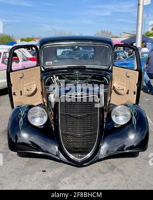 FRESNO, UNITED STATES - Apr 03, 2021: A front view photo of an all black painted Vintage Ford Roadster with engine exposed and two doors open with cus Stock Photo