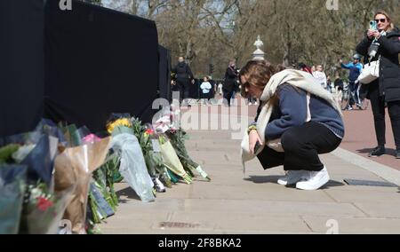 Floral tributes being laid outside Buckingham Palace, London, following the death of the Duke of Edinburgh at the age of 99 on Friday. Picture date: Tuesday April 13, 2021. Stock Photo
