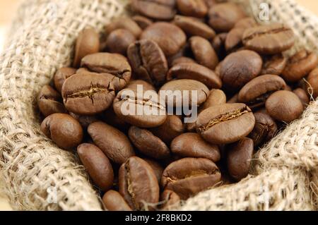Roasted coffee beans in sacking bag. Selective focus. Stock Photo