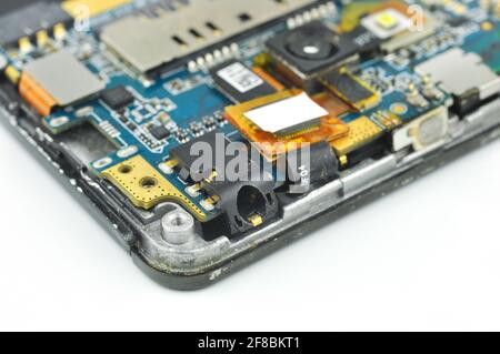 Disassembled mobile phone or smartphone. Circuit board, camera, microcircuit, audio jack. Macro photo. Stock Photo