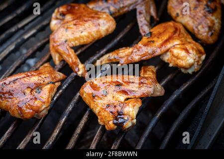 glazed bbq chicken wings cooked on the grill closeup Stock Photo