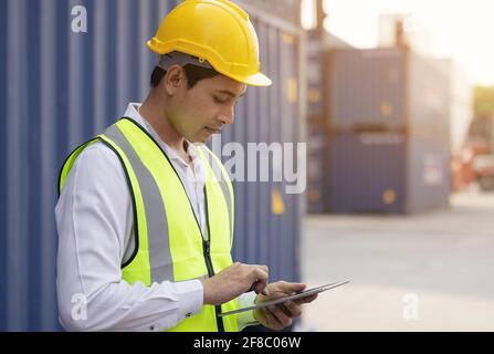 Male engineer, worker inspection checking on container by using tablet. Stock Photo