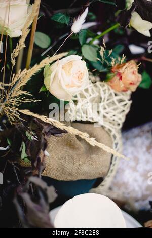 Closeup detail shot of elegant rustic wedding bouquet and reception setup, white roses, burlap, purple Stock Photo