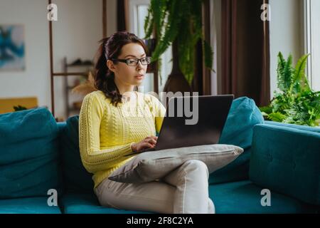 Businesswoman typing an e-mail on laptop at home office. Stock Photo