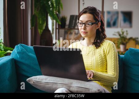 Businesswoman typing an e-mail on laptop at home office. Stock Photo