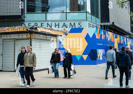 London, UK. 13 April 2021.  People pass colourful hoardings hiding the former Debenhams flagship store in Oxford Street following the UK government’s coronavirus roadmap out of lockdown which allowed non-essential shops to reopen the previous day.  Credit: Stephen Chung / Alamy Live News Stock Photo