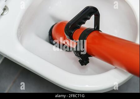 Professional force pump cleaner in toilet bowl. Stock Photo