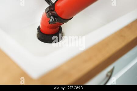 Professional force pump cleaner in the kitchen sink. Stock Photo