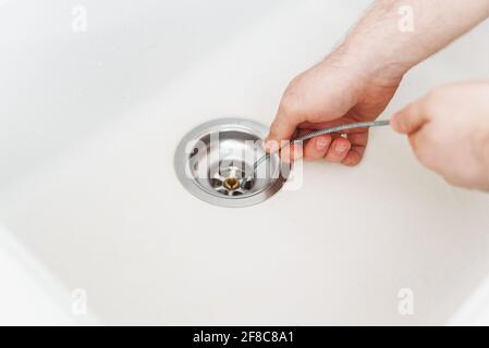 https://l450v.alamy.com/450v/2f8c8a1/plumber-using-drain-snake-to-unclog-kitchen-sink-2f8c8a1.jpg
