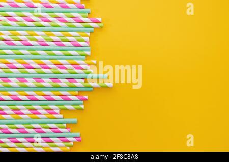 Multicolored party drinking straws on yellow background, Stock Photo