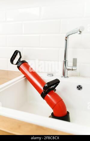 Professional force pump cleaner in the kitchen sink. Stock Photo
