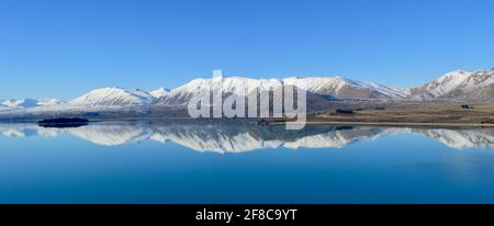 Snow-capped mountains reflected in Lake Tekapo, New Zealand Stock Photo