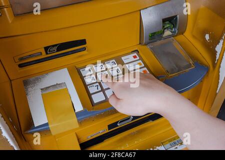 Close up of woman hand entering password code on ATM bank machine keypad Stock Photo